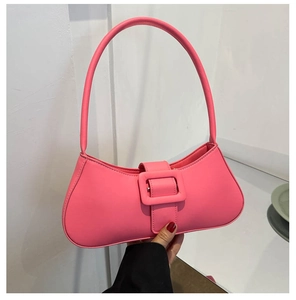 Détail du sac baguette carré rose en similicuir mat avec une boucle décorative sur le devant