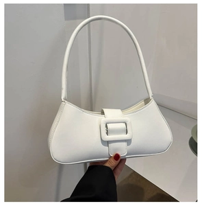 Gros plan sur un sac baguette en cuir blanc avec une grande boucle décorative carrée