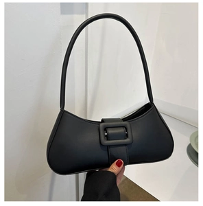Gros plan d'un sac baguette en cuir noir avec une grande boucle carrée décorative