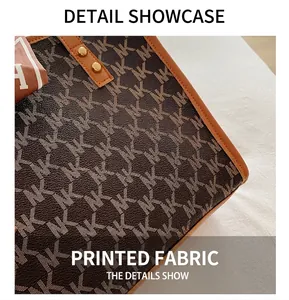 Close-up of monogram print tote bag with brown leather trim and gold hardware