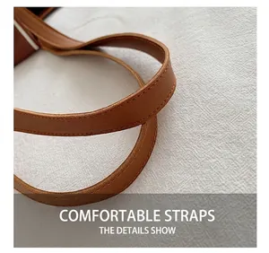 Detail of soft brown leather shoulder strap with reinforced stitching on a tote bag