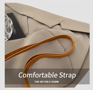 Detail showing the slender orange leather shoulder strap of a retro square tote bag