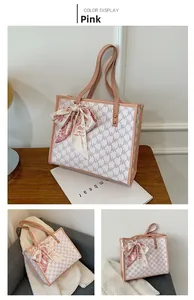 Detail of pink and white NK monogram tote bag with floral silk bow charm on handles