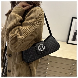 Vue détaillée d'un sac porté épaule noir avec monogramme et logo M argenté sur un mannequin