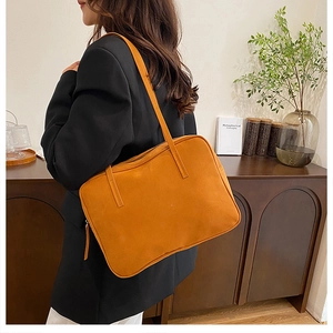 Orange yellow tote bag made of soft matte leather shown in a cozy home setting