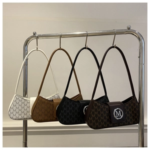 Détail de quatre sacs sous les bras à motifs en crème, marron, noir avec logo M