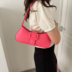 Sac baguette rose fluo avec boucle carrée, porté à l'épaule pour un style rétro et chic