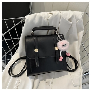 Mini sac à dos en cuir noir avec ferrures dorées et breloque pelucheuse rose