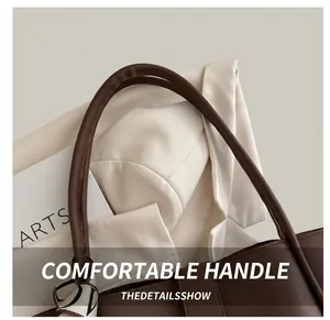 Detail of brown tote bag handle featuring a geometric silk scarf and elegant texture