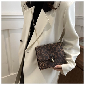 Detail of leopard print crossbody bag featuring a gold chain strap and metallic lock closure