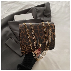 Detail of leopard print crossbody bag with gold chain strap and metal lock closure