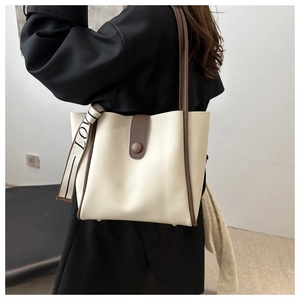 Detail of cream tote bag with dark brown straps and stylish LOVE ribbon decoration