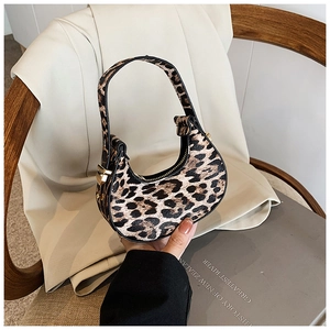 Detailed close-up of a mini crescent bag with leopard print and elegant gold hardware