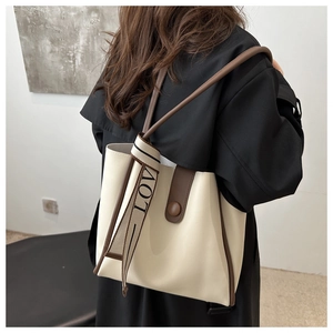Detail of off-white tote bag with brown trim and LOVE ribbon on the shoulder strap