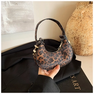 Detail of hobo crescent mini bag featuring leopard print texture and gold metal zipper