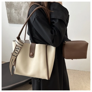 Detail of minimalist cream tote bag set with brown trim and LOVE ribbon handle decoration