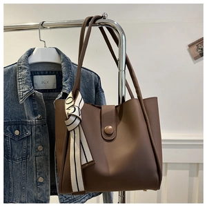 Brown matte tote bag with round buckle detail and silk scarf on metal hanger