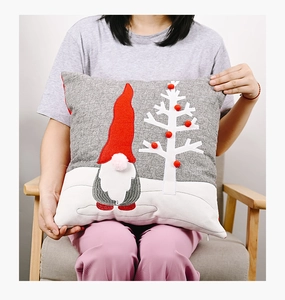 Detail of grey gnome pillow cover with red hat embroidery and textured 3D pom-pom