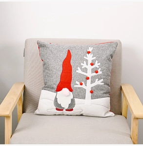 Detail of grey linen pillow cover featuring a gnome applique and plush Christmas tree