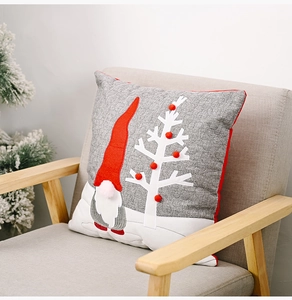 Detail of grey linen pillow cover featuring a 3D gnome applique and Christmas tree
