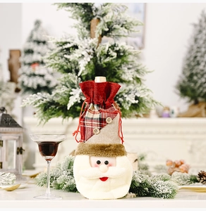 Detail of Christmas wine bottle cover with Santa face, buttons and red plaid pattern