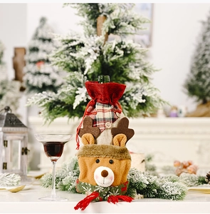 Detailed view of reindeer wine bottle cover with red and green plaid fabric and plush decor