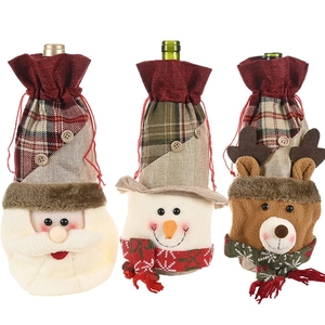 Three-piece burlap Christmas wine bottle covers featuring Santa, snowman, and elk designs