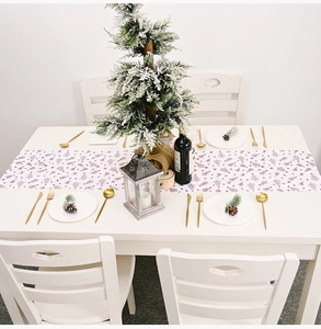 Détail du chemin de table blanc avec sapins rouges et décorations de fête