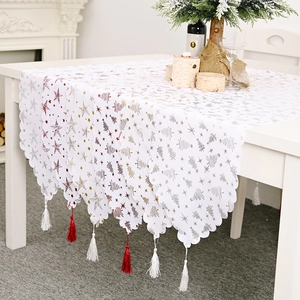Chemin de table de Noël avec étoiles dorées et franges festives sur une table blanche