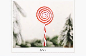 Detail of red and white spiral acrylic candy cane ornament with festive bokeh background