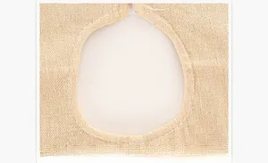Detailed macro view of beige burlap fabric texture and stitched center hole of the tree skirt