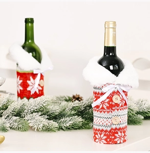 Close-up of knitted Christmas wine bottle covers with snowflakes and wooden buttons