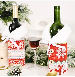 Detail view of festive knitted Christmas wine bottle covers with snowflakes and deer motifs