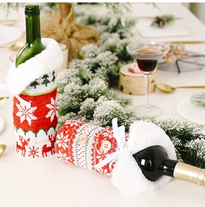Close-up of a festive red knitted wine bottle cover with faux fur collar and snowflake patterns