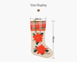Size display of burlap Christmas stocking with red poinsettia flowers and plaid cuff details
