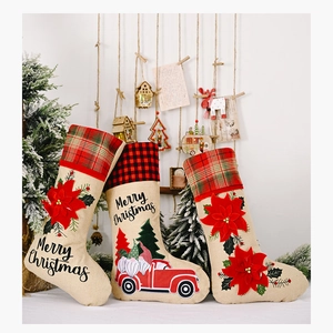 Three burlap Christmas stockings with poinsettia, red truck and gnome patterns in a festive set
