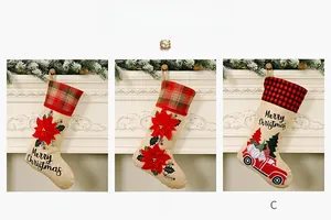 Detailed view of three burlap Christmas stockings with poinsettia and red truck motifs