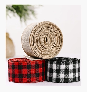 Close-up of three rolls of Christmas buffalo plaid and natural jute ribbons for DIY crafts