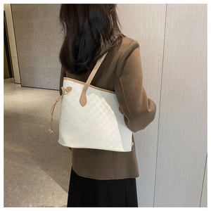 Detailed macro view of ivory tote bag with textured checkerboard pattern and brown strap