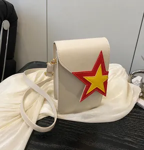 Detail view of cream mini crossbody phone bag with red and yellow star patch