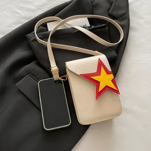 Crossbody phone bag detail showing storage capacity and red star patchwork on beige PU leather