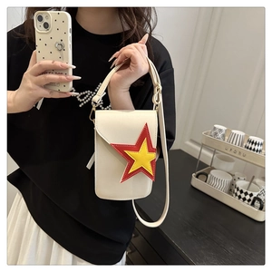 Detail of off-white crossbody phone bag with red and yellow star patchwork embroidery