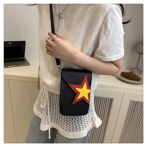 Detail of black crossbody phone bag featuring a 3D red and yellow star on the leather flap