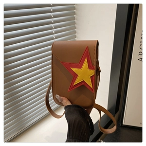 Detail van een bruine leren crossbody telefoontas met een rode en gele sterrenpatch