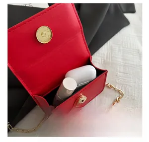 Detalle del interior del mini bolso rojo mostrando capacidad para labial y cascos