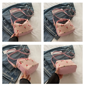 Detail of pink corduroy shell bag with cherry embroidery and premium leather stitching