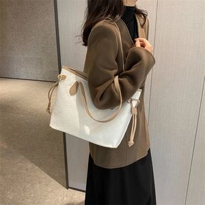 Minimalist beige tote bag with checkered texture and brown handles for daily use