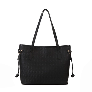 Minimalist black tote bag featuring elegant diamond quilted texture and gold D-ring accents