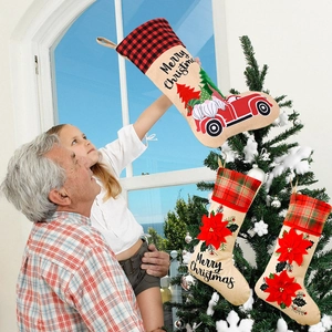 Three burlap Christmas stockings with gnomes, red truck and poinsettia patterns for decor
