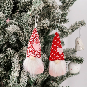 Valentine's Day gnome plush pendants with red and white knit hats on snowy tree branches